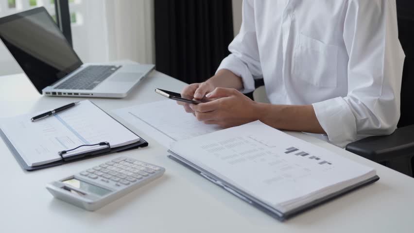 Asian businessman using smartphone at work place.