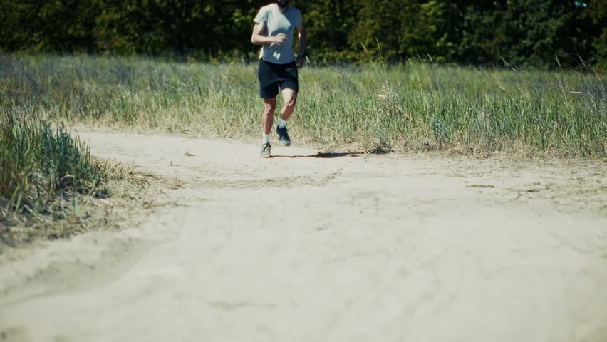 Professional Runner Training On Outdoor Road During Summer, Active Runner Exercising On Dusty Outdoor Road Path, Athletic Runner Jogging Along Rural Outdoor Road Way, Sports Performance In Natural Environment, Healthy Lifestyle And Physical Activity, Morning Workout In Green Meadow, Cardio Training For Endurance Goals, Sprint Motion In Countryside Landscape, Fitness Routine Under Sunlight, Daily Exercise For Body Health