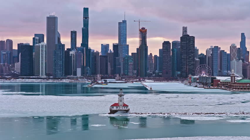 Telephoto drone shot of the Chicago Harbor Lighthouse and the cityscape, winter