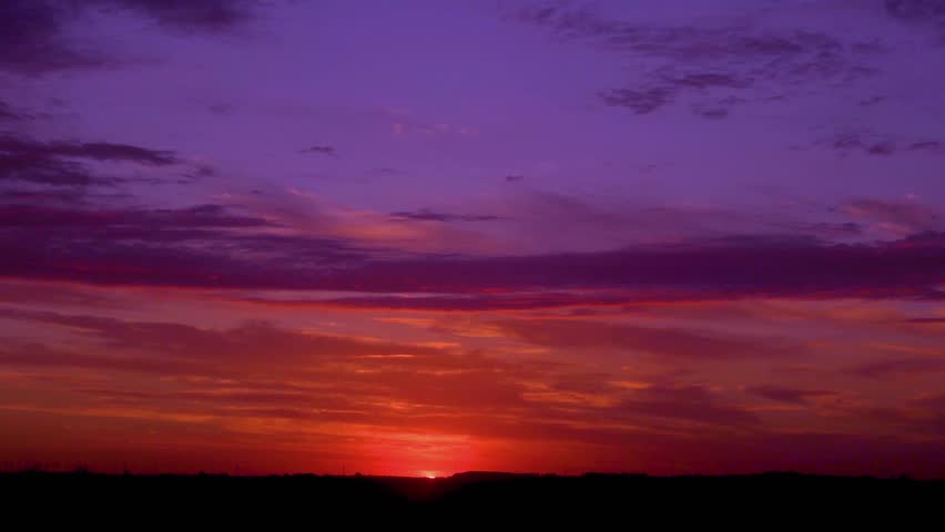 Incredible bright colorful dawn sky shining sun with rays and beams sunlight horizon colored clouds in the field fast time lapse. Morning color twilight sky sun clouds, sunrise meadow background 4K