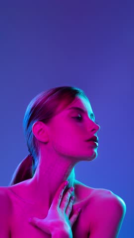 Woman touching neck with glowing skin grid mapping under neon lighting on gradient background. Concept of beauty technology, anti aging care, digital skincare analysis and emotional aesthetic appeal.