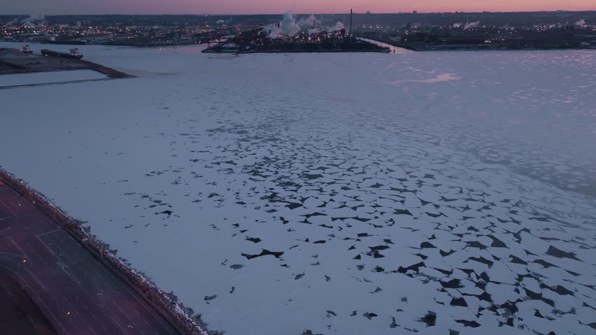 Sunset over frozen lake in Hamilton, Ontario, capturing a tranquil vibe