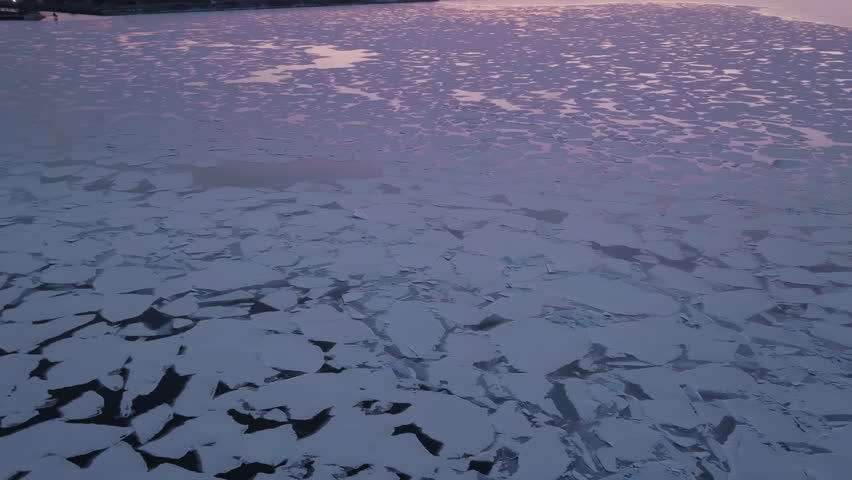 Frozen Hamilton Harbour at sunset with icy landscape and industrial view