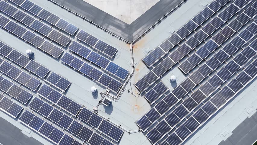 Cinematic drone footage flies over rooftop solar power plant on outdoor swimming pool in Halifax, Nova Scotia, Canada. Solar modules generate clean renewable energy, sunny summer day 4K.