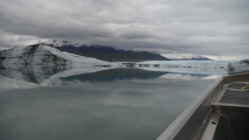 Cinematic handheld POV footage of a small boat navigating through ice chunks and icebergs on Matanuska Glacier in Alaska.  Ideal for dramatic, adventure, relaxing, travel, outdoor, and glacier-themed projects. 