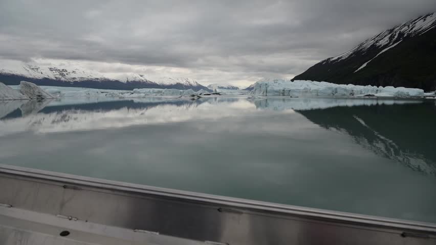 Cinematic handheld POV footage of a small boat navigating through ice chunks and icebergs on Matanuska Glacier in Alaska.  Ideal for dramatic, adventure, relaxing, travel, outdoor, and glacier-themed projects. 