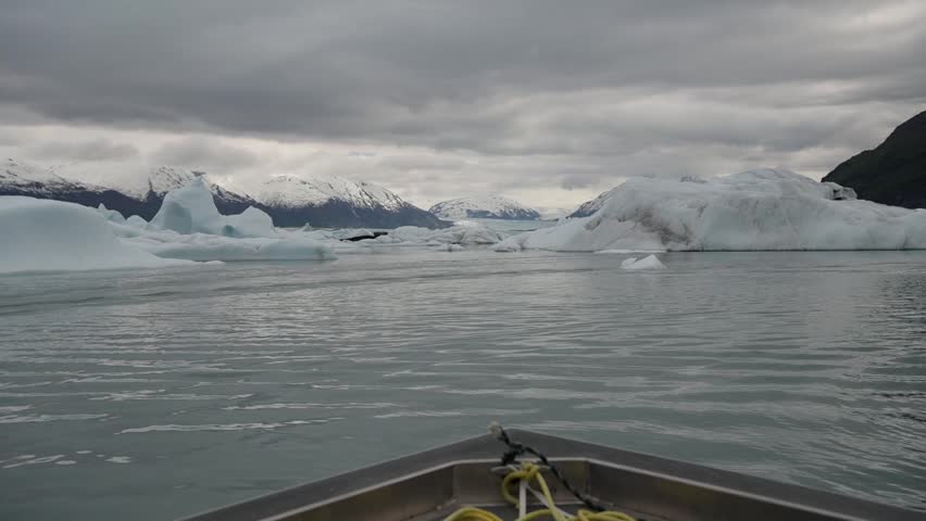Cinematic handheld POV footage of a small boat navigating through ice chunks and icebergs on Matanuska Glacier in Alaska.  Ideal for dramatic, adventure, relaxing, travel, outdoor, and glacier-themed projects. 