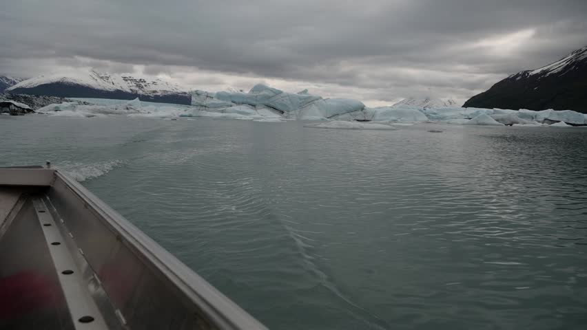 Cinematic handheld POV footage of a small boat navigating through ice chunks and icebergs on Matanuska Glacier in Alaska.  Ideal for dramatic, adventure, relaxing, travel, outdoor, and glacier-themed projects. 