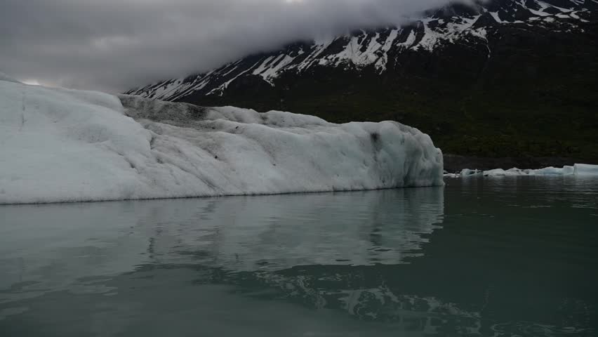 Cinematic handheld POV footage of a small boat navigating through ice chunks and icebergs on Matanuska Glacier in Alaska.  Ideal for dramatic, adventure, relaxing, travel, outdoor, and glacier-themed projects. 
