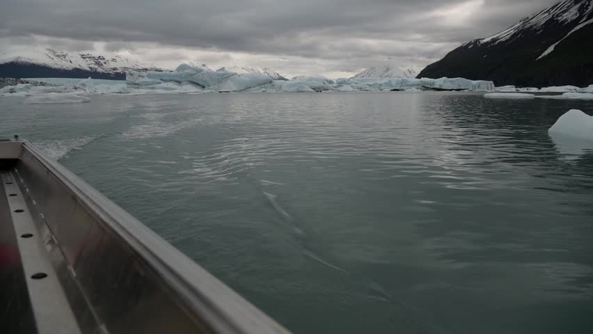 Cinematic handheld POV footage of a small boat navigating through ice chunks and icebergs on Matanuska Glacier in Alaska.  Ideal for dramatic, adventure, relaxing, travel, outdoor, and glacier-themed projects. 