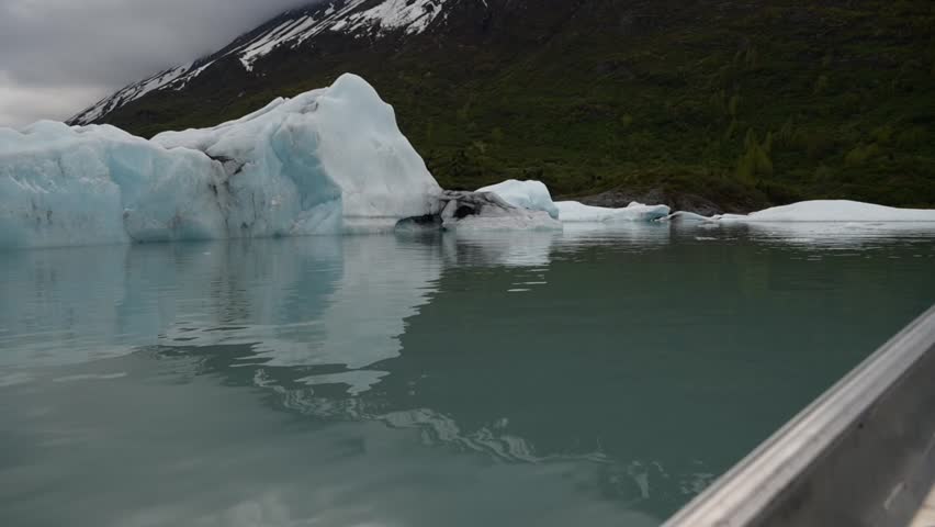 Cinematic handheld POV footage of a small boat navigating through ice chunks and icebergs on Matanuska Glacier in Alaska.  Ideal for dramatic, adventure, relaxing, travel, outdoor, and glacier-themed projects. 