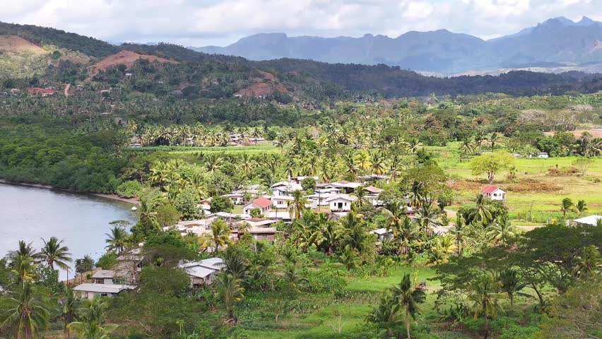Aerial remote village with houses and community buildings in jungle. Fiji Islands, South Pacific.