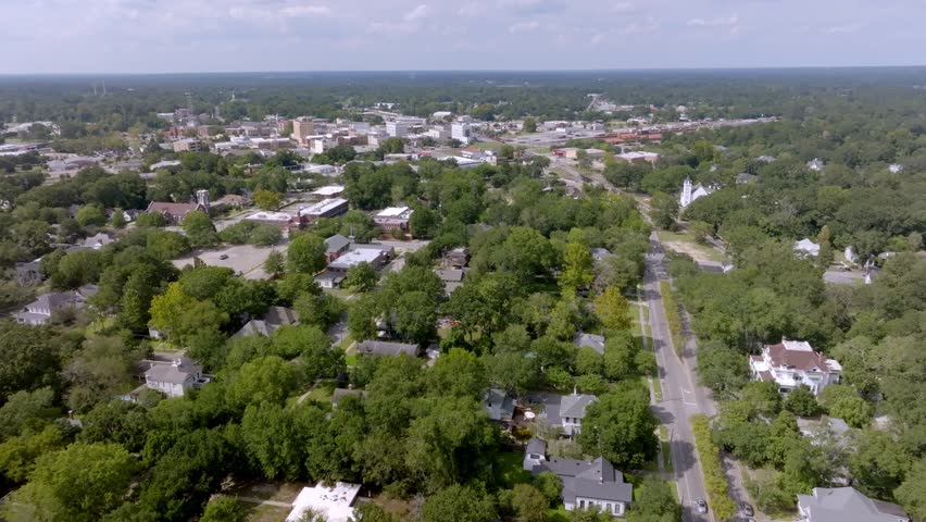Neighborhood homes in Hattiesburg, Mississippi with drone video moving in wide shot.