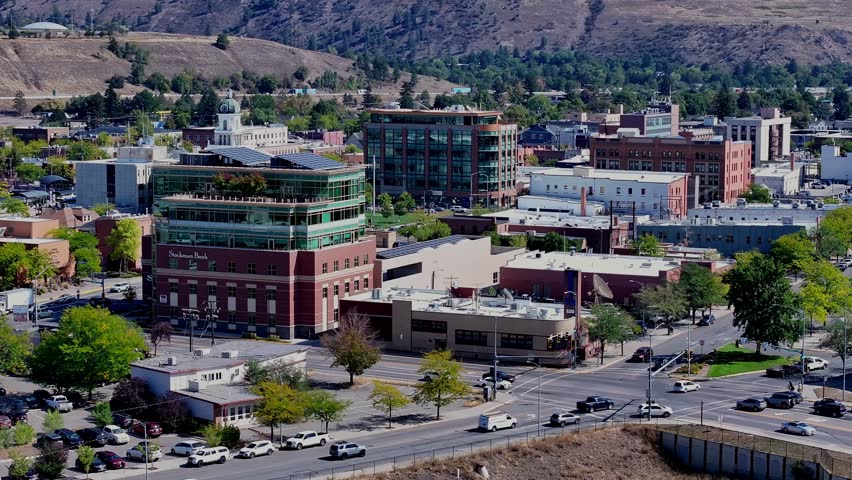Close aerial telephoto orbit of downtown Missoula Montana buildings historic courthouse and intersections
