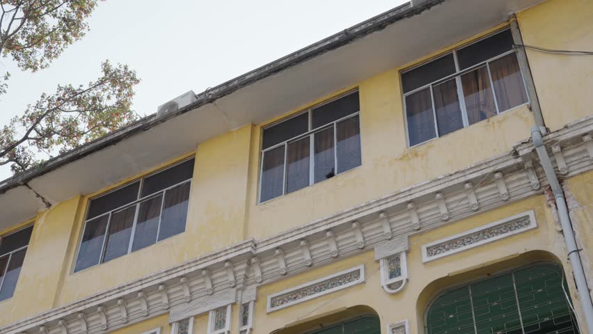 Close-up of building facade with windows and architectural detail, minimal urban texture.