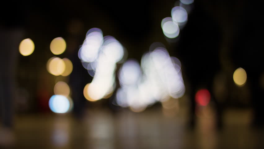 Slow motion of crowds of people walking and blurred lights shot with super shallow focus