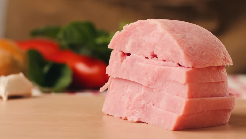 Ham italian mordatella, man Slices Of Traditional Italian antipasti mortadella sausage on a wooden cutting board, close up macro of chicken or turkey jamon, fat breakfast dish.