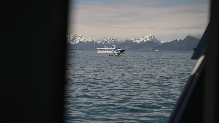 Slow motion POV footage from a boat traveling through Kenai Fjords National Park, Alaska, with other boats navigating the fjords.  Ideal for cinematic, travel, and nature productions. 