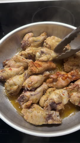 Spicy chicken wings frying in a pan