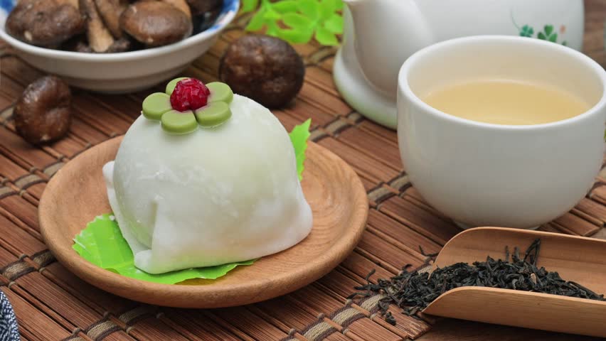 Matcha-flavored Japanese mochi on the wooden plate 
