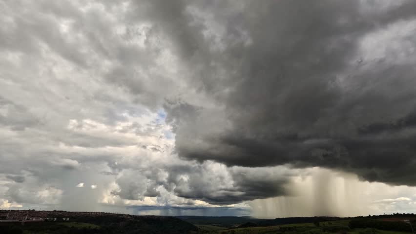 A powerful and dramatic black and white time-lapse video showing dark, heavy storm clouds rapidly forming and covering the sky over a distant city skyline. This monochrome footage captures the raw force of nature and the ominous beauty of an approaching weather front. The movement of the clouds creates a sense of urgency and impending drama, making it perfect for projects related to meteorology, climate change, nature