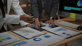 Business colleagues review financial data and shake hands after reaching an agreement - Powered by Shutterstock - Get 15% off with code: PIKWIZARD15