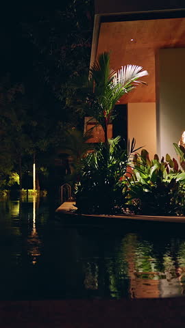 Resort pool beside modern building at night with warm lighting forming Luxury Escape and cinematic tropical calm.