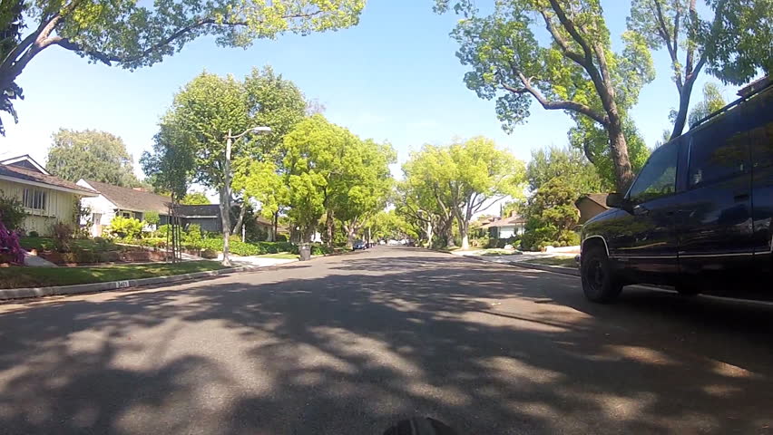 The point of view of someone riding a bicycle down the middle of a suburban