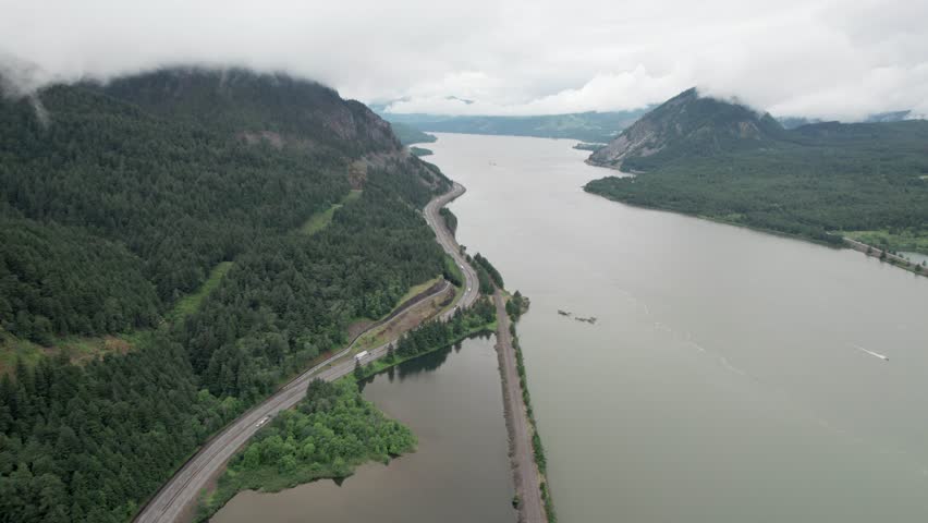 Aerial view of Columbia River Gorge with highway traffic and misty mountains in Oregon