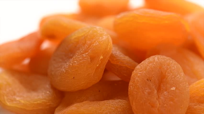 Dried apricots background close-up. Apricot fruits. Ripe Organic Apricots fruit rotating backdrop. Close up. Heap of dried apricot background, vegan food, macro shot