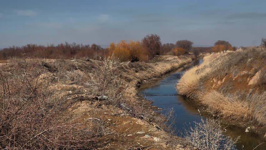 A lonely river, rural expanses, autumn landscape and a motorcycle passing by
