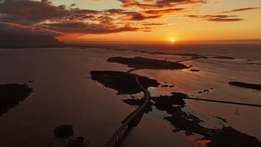 Atlantic Ocean Road bridges connecting islands at dramatic sunset over calm sea, Norway, hyperlapse