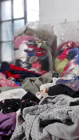 Used childrens clothes and shoes in bales for donation. Fast fashion clothing waste and overconsumption concept