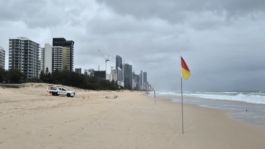 Surf Lifesavers Sitting in Beach Patrol Truck Under Rain Clouds – Surfers Paradise in Background