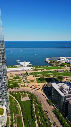A stunning high-angle shot showcasing the iconic Milwaukee Art Museum, lush green parks, and the deep blue waters of Lake Michigan on a clear day.