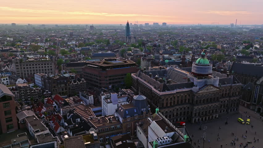 Aerial view of Amsterdam city at sunset, Netherlands. Amsterdam Central Station. Canals with boats in the center city, old centre 