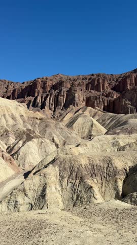 A dramatic vertical view of the fluted red rock columns and eroded badlands of Red Cathedral in Death Valley National Park. (9:16 Vertical)