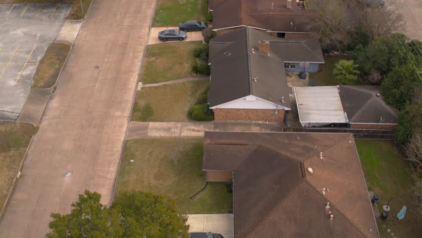 Aerial view capturing well-maintained single-family homes on tree-lined streets in a quiet East Houston neighborhood. Ideal for family and community lifestyle projects