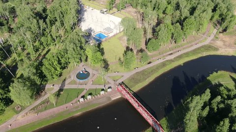 Drone Flying Backward above River Park Bridge