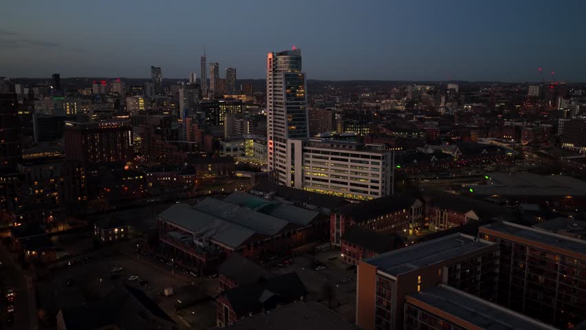 Aerial footage in the night time of the city centre of Leeds in West Yorkshire in yje UK, showing high rise apartments on the outskirts of the British city from above in the evening 