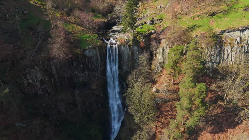 A drone rising pullout view of the Pistyll Rhaeadr waterfall in Powys, Wales, UK bringing the Berwyn moorland into view