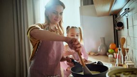 Adorable mom daughter frying pancakes indoor closeup. Caring woman teaching child girl to cook at kitchen. Happy smiling mother kid cooking together at warm light house. Family traditions concept - Powered by Shutterstock - Get 15% off with code: PIKWIZARD15