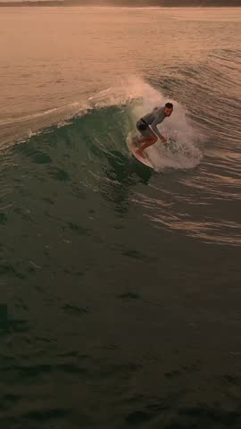 Sunset Aerial SlowMotion Caucasian Surfer Carving Green Wave With Golden Spray, Longboard Control, Deep Rail