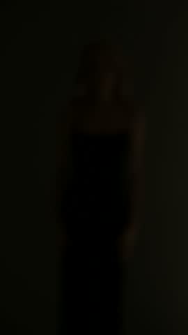 Fashion photo of young beautiful woman in black dress posing in studio