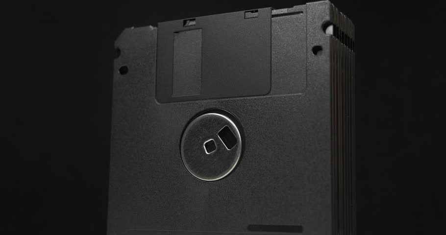 Black floppy diskettes. Floppy disk, diskette, or floppy diskette - type of disk storage made from a thin, flexible disk coated with magnetic storage medium. Cinema 4K 60fps video on black background