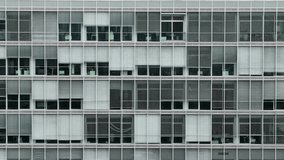 Front view of a modern office building facade with repetitive glass windows and blinds, showing corporate architecture and geometric design pattern. - Powered by Shutterstock - Get 15% off with code: PIKWIZARD15