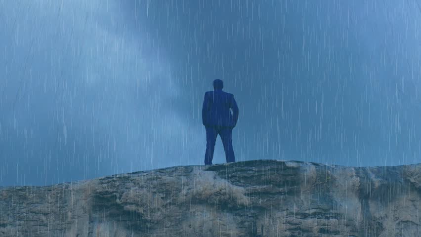 silhouette of a man standing in thought during a storm