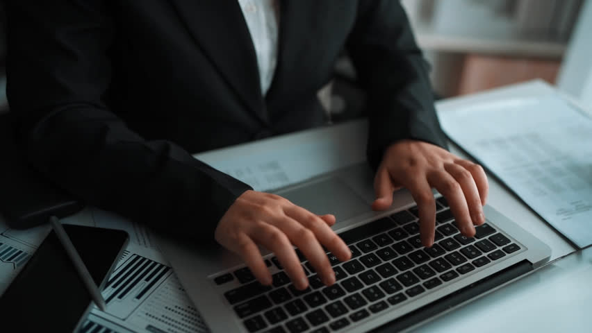 Business professional working with digital AI technology on laptop, surrounded by data visualizations and analytics in a modern office setting Sigmoid