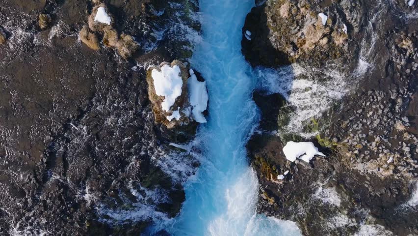 High aerial top down over vivid turquoise Bruarfoss river sliding frame down