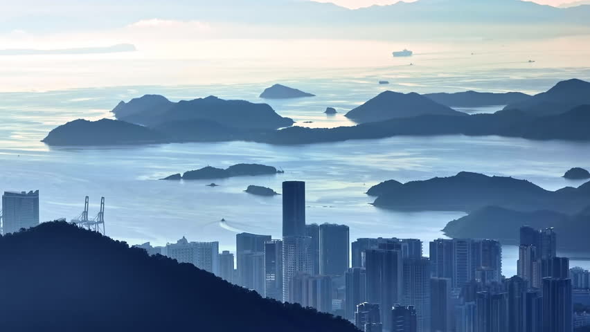 High angle view of Hong Kong city skyline and Victoria Harbour during misty dawn, reflecting global financial hub and urban development, Hong Kong, China.